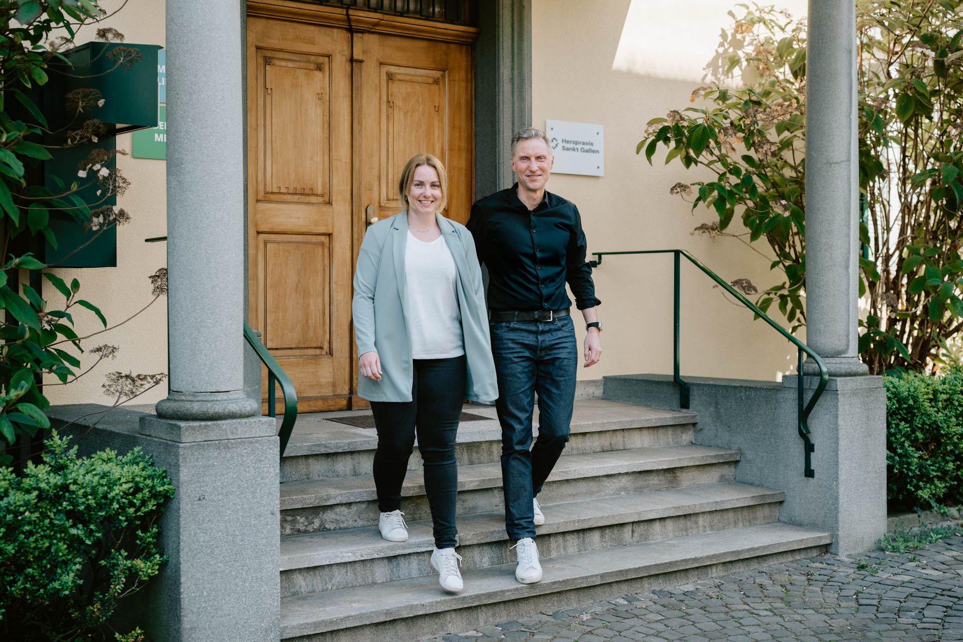 Stephan Schneiter und Micaela Baumgartner vor dem Eingang der Herzpraxis Sankt Gallen